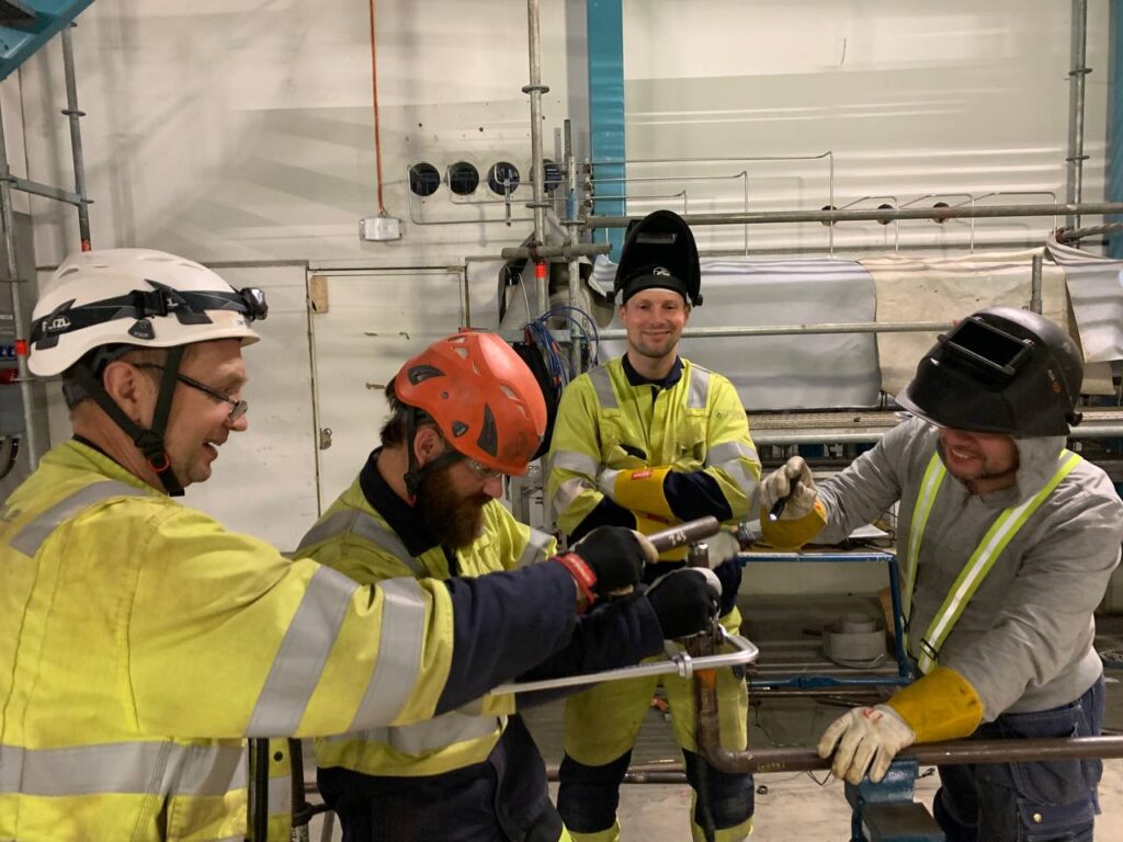 Pipe Fabrication: smiling installers assembling a pipeline