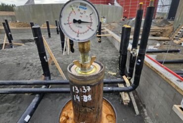 Biogas plant installation – hydro test of pipeline with biogas reactors in background